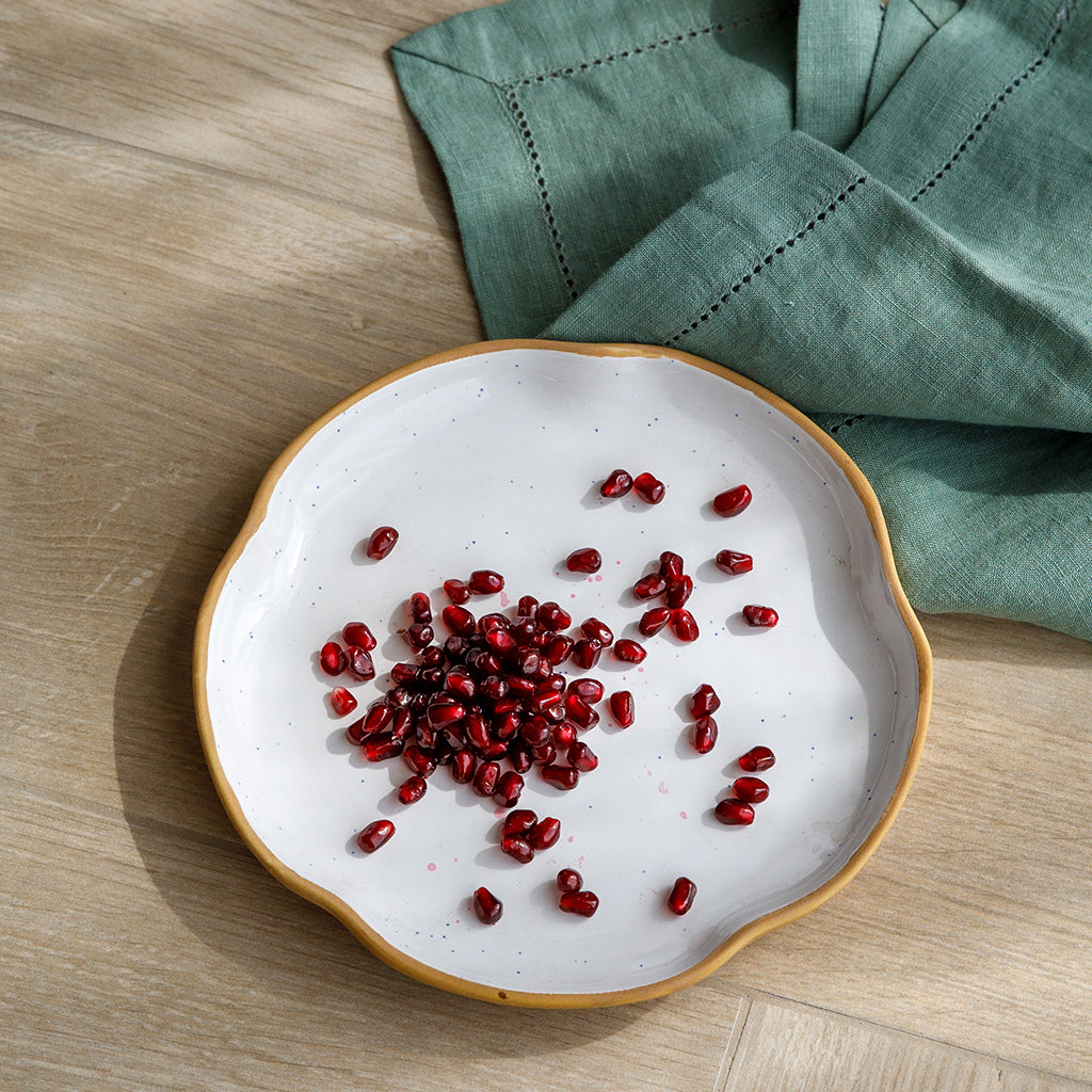 A set of four side plates made of a ceramic stoneware with contemporary curved edges, set off food beautifully.