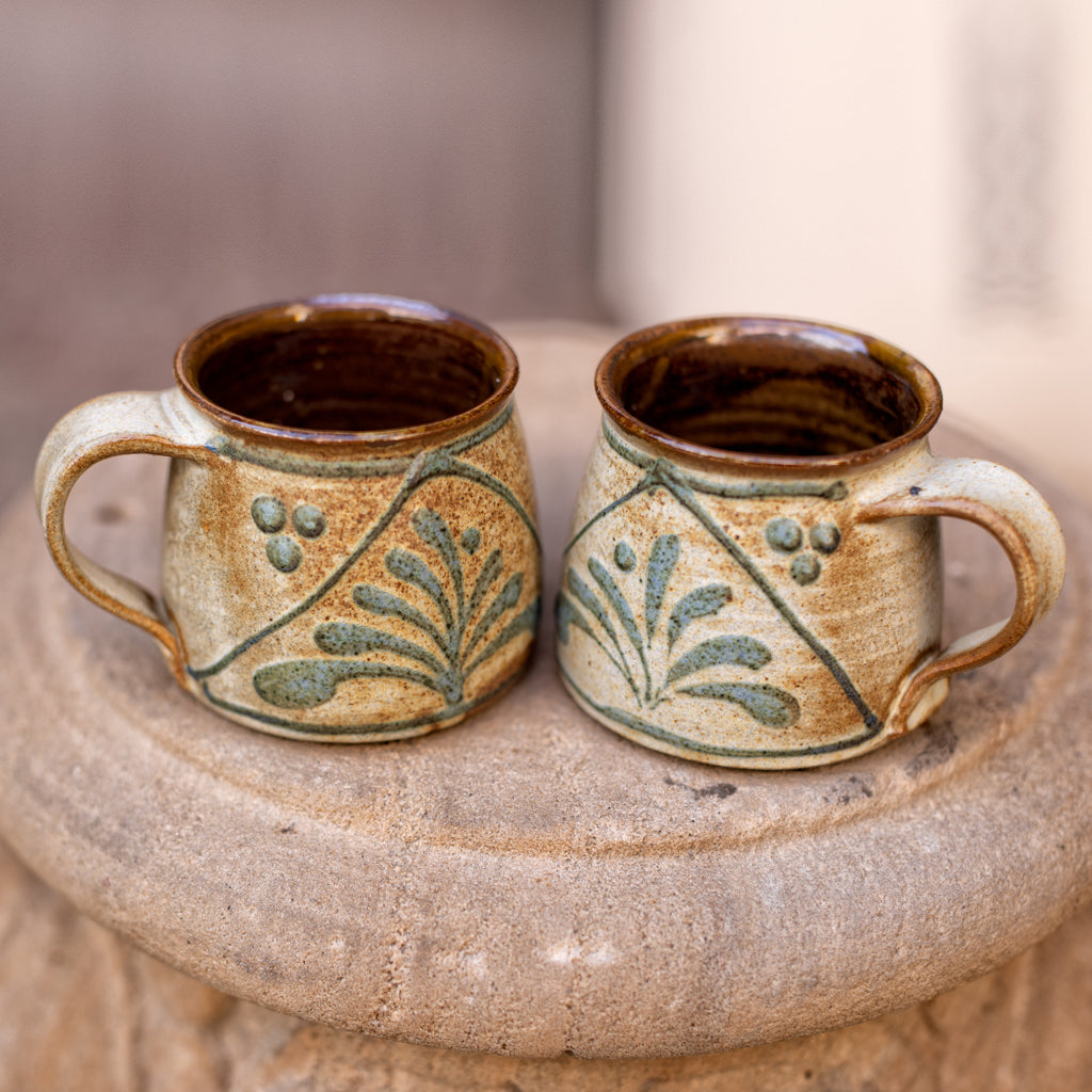 A handmade ceramic palm coffee mug - small, Inspired by nature, this mug in an ivory sepia glaze is hand painted with a palm tree motif.