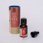 A bottle of Curate Home Brand Rub'al Khali Sunrise Diffuser Oil with its cap and dropper removed, placed next to its colorful packaging box.