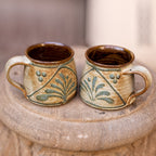 A handmade ceramic palm coffee mug - small, Inspired by nature, this mug in an ivory sepia glaze is hand painted with a palm tree motif.